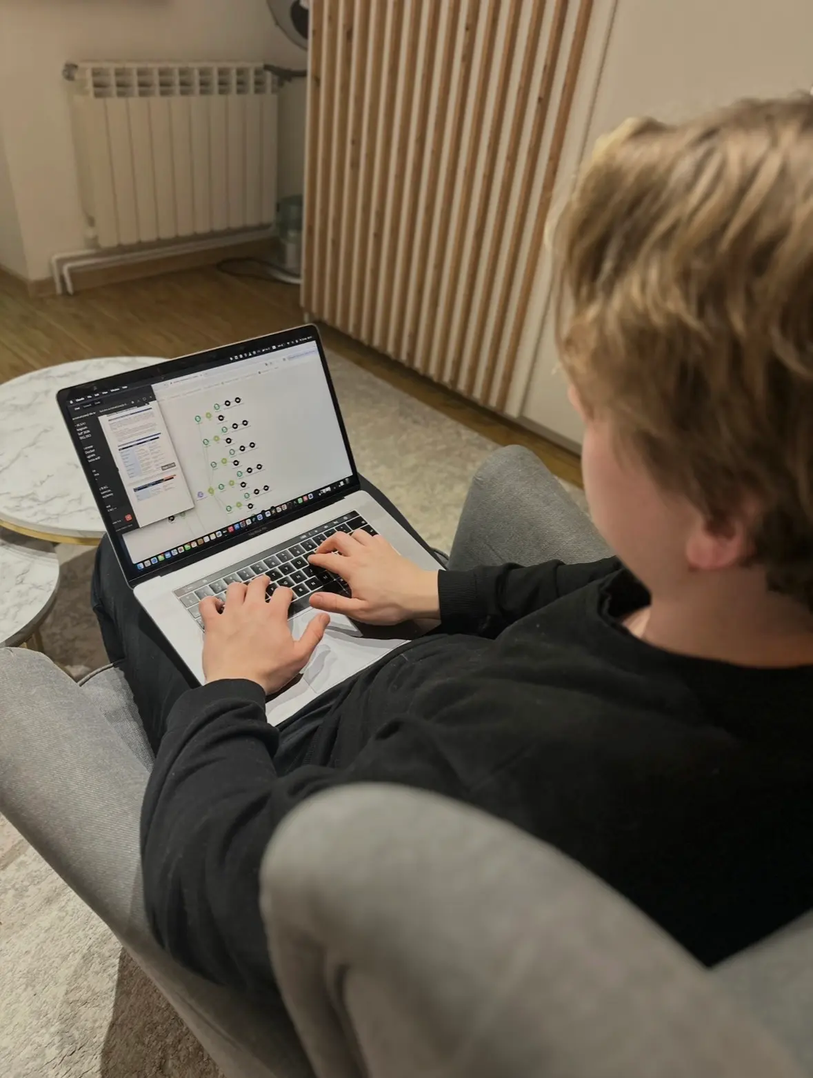 Radosław widziany zza ramienia podczas pracy przy laptopie.